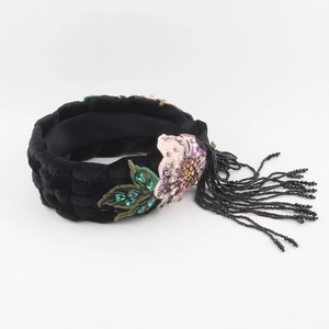 Braided black velvet headband featuring floral embroidery and long beaded tassels