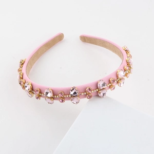 Detailed view of pink fabric headband with assorted crystal shapes in gold claw settings