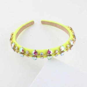 Macro shot of neon yellow headband featuring multi-colored rhinestones on white display
