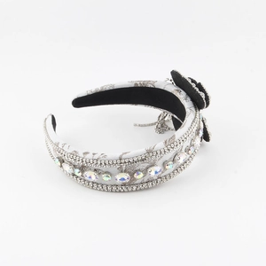 Dettaglio di un cerchietto barocco largo con strass, gemme colorate e decorazione floreale
