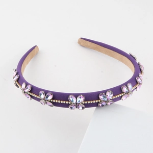 Close-up of purple fabric headband with sparkling crystal flowers and gold chain detail
