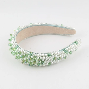 Dettaglio del cerchietto barocco con perle bianche e cristalli verdi brillanti