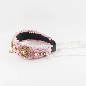 Close-up of pink braided headband featuring inlaid rhinestones and pearl chain details