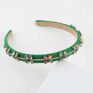 Detail of emerald green fabric headband with iridescent crystal flowers and rhinestones