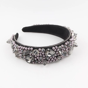 Detail of luxury padded headband with gray rhinestones and faux pearls on black velvet