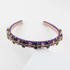 Detailed view of luxury purple headband with rhinestone flower clusters and gold setting