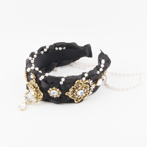Detail of luxury black braided headband with gold accents, colorful rhinestones and pearls