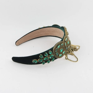 Détail du serre-tête vintage en velours vert émeraude avec glands en cristal