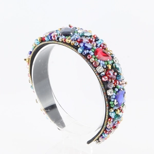 Close-up of handmade baroque headband with colorful crystals and rhinestones on black fabric