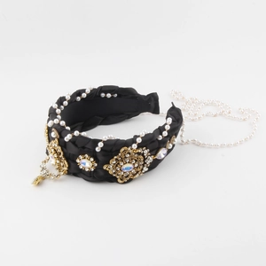 Macro view of woven satin headband with golden floral metal pieces and iridescent crystals