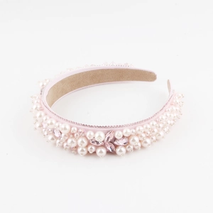 Détail du serre-tête baroque rose avec perles blanches et ornements en cristal brillant