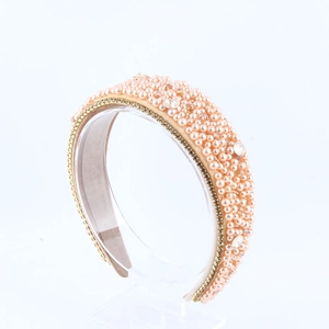 Detail of pink sponge headband with pearls, crystals, and gold chain trim decoration