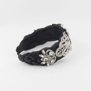 Détail du serre-tête en satin noir tressé avec ornements de feuilles en cristal