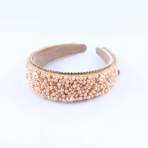 Macro detail of hand-beaded champagne pearl headband with sparkling rhinestone accents