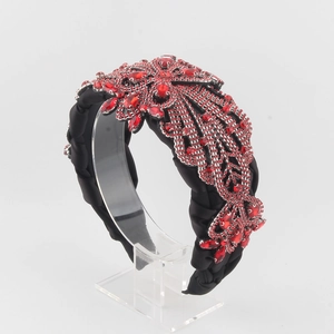 Détail d'un serre-tête en satin noir avec broderie florale en cristaux rouges cousue main