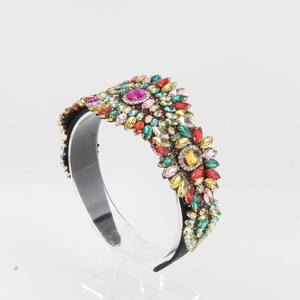 Dettaglio di cristalli colorati e strass incastonati su un cerchietto barocco di lusso
