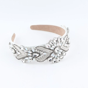 Detailed view of rhinestone headband with crystal flower patterns on a wide white base