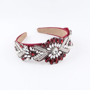 Detail of red baroque headband with intricate crystal floral pattern and velvet base