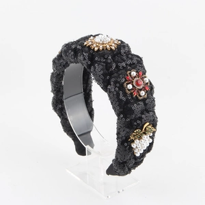 Vue rapprochée du serre-tête à paillettes noires orné de fleurs en perles et gemmes