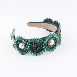 Détail du serre-tête en velours vert émeraude avec strass floraux et perles blanches
