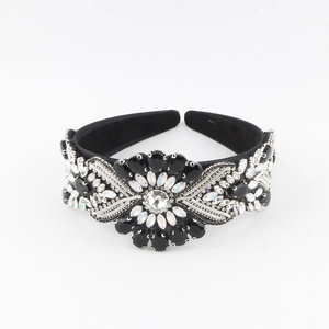 Close-up of Baroque velvet headband with crystal sun flower and intricate rhinestone patterns