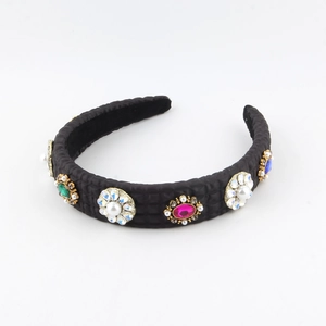 Close-up of vintage baroque headband with colorful gemstones and white imitation pearls