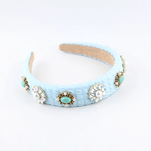 Detail of light blue faux leather headband with pearl starburst and blue stone accents