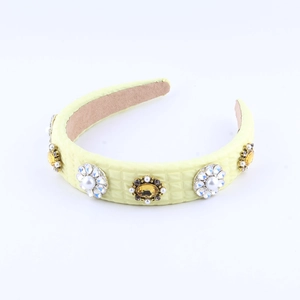 Detail of yellow padded headband featuring quilted texture and pearl rhinestone clusters
