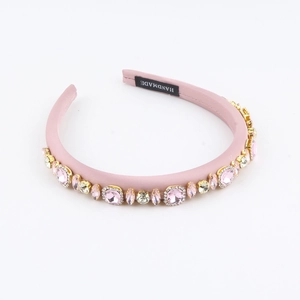 Detail of a pink handmade headband with sparkling rhinestones and a satin texture