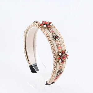 Close-up of woven headband with red crystals, white pearls and gold sequins detail