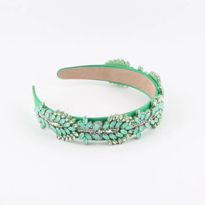 Detail of green baroque headband with hand-set rhinestones and floral pattern crystals