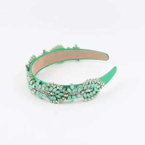 Detail of green baroque headband featuring emerald crystal flowers and satin fabric texture
