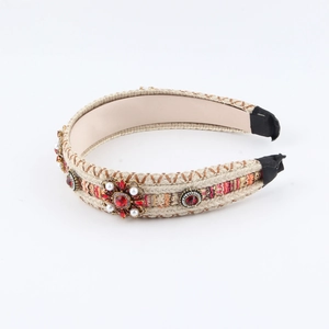 Detailed view of bohemian braided headband with red rhinestones and pearls