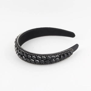 Detailed macro view of black faceted crystals and silver rhinestones on the velvet headband