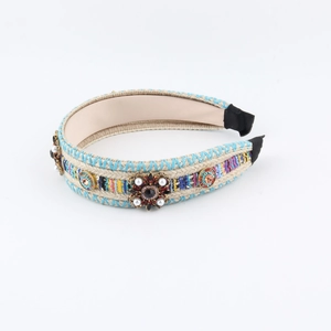 Detail of bohemian woven headband with vintage flower charms, pearls and colorful rhinestones