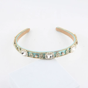 Detail of luxury padded headband featuring turquoise rhinestones, pearls, and gold bead trim