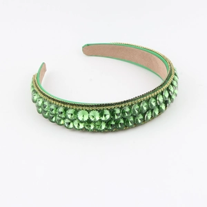 Detail of luxury green baroque headband with sparkling rhinestones and gold chain trim