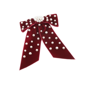 Elegant burgundy velvet bow hair clip with faux white pearls on white background