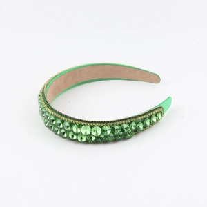 Detailed view of green crystal headband with emerald rhinestones and non-slip inner lining
