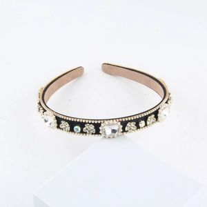 Detail of luxury padded headband with square crystals and aurora rhinestones on black fabric
