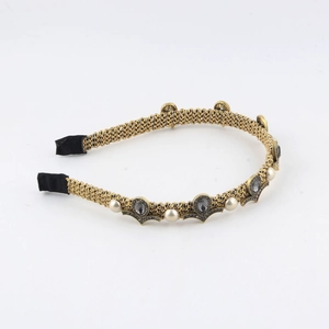 Retro golden woven headband with white pearls and grey teardrop gemstones on white background