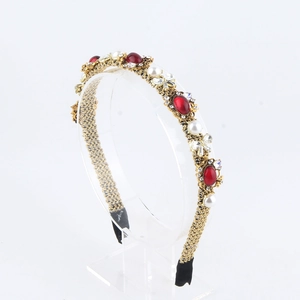Detailansicht goldener Haarreif mit roten Edelsteinen, Perlen und Kristallen im Retro-Stil