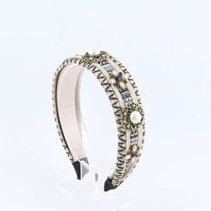 Detail of tweed headband with white pearls, gold metal accents and black gemstone embellishments