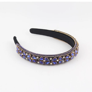 Close-up of luxury velvet headband featuring blue teardrop rhinestones and floral metalwork