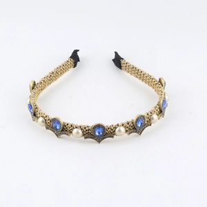 Close-up of vintage gold metal headband with blue teardrop gems and white pearls