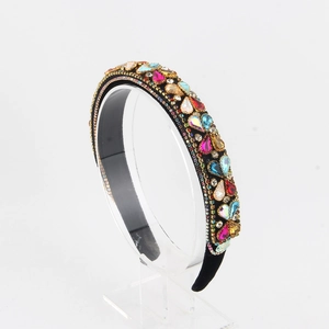 Close-up of colorful rhinestones on a black velvet headband with detailed claw settings