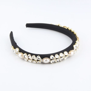 Detail of luxury padded headband with shimmering rhinestones and faux pearls on black velvet