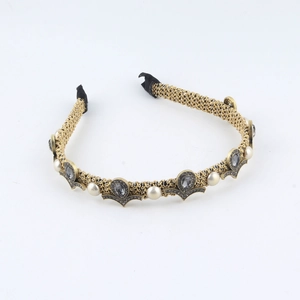 Detail of vintage gold braided headband with grey stones and white pearls on white background
