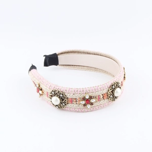Chic beige knitted headband featuring pink stitching, pearls, and vintage red gemstones