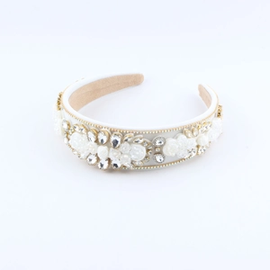Détail d'un serre-tête en satin blanc de luxe avec fleurs faites main et strass brillants